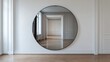 © Sinechana - 41.A contemporary hallway with a large round mirror mounted on a white wall, reflecting the bright and spacious design of the open-plan apartment, featuring wooden floors and muted decor tones.