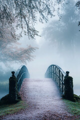 Wall Mural - A misty, serene woodland scene with a rustic bridge over a fog-covered stream, surrounded by lush trees and autumn leaves, creating a mystical ambiance.