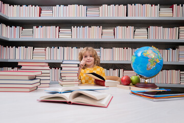 Fototapete - School and students in classroom. Education kids. Child pupil student in the school class. Studying and learning concept. School boy in the library near school supplies. Kid learn geography with globe