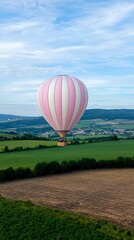 Wall Mural - a colorful hot air balloon floats gracefully over lush green fields under a clear blue sky.