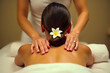 © SnapScape - Woman in a white dress receives a back massage, flower in hair