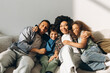 © Maria Vitkovska - Happy African American family embracing on sofa at home