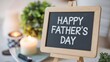 © Media Srock - Happy Father's Day! A heartwarming message on a chalkboard easel, surrounded by candles and plants, perfect for a Father's Day celebration.