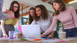 © Monkey Business - Multi-Cultural Female Business Team Meeting In Office Looking At Laptop Digital Tablet And Documents
