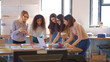 © Monkey Business - Multi-Cultural Female Business Team Meeting In Office Looking At Laptop And Documents