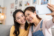 © GTNA73 - Happy Asian mother daughter do selfie shot on mobile cell phone at home. Closeup. Family parent day concept.