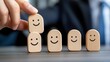 © taweesak - Individual concentrating on placement of wooden block with smiley face as a symbol of creativity and playfulness in design