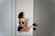 © olezzo - Beautiful young woman with eyes closed sitting on bed at home