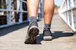 © Austockphoto - Close up of joggers shoes walking over bridge