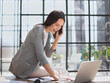© Katsiaryna - Businesswoman with phone in modern office talking