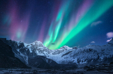 northern lights over the snowy mountains at night in lofoten, norway. aurora borealis above the snow