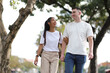 © Kainnika - Two young tourists happily walk hand in hand in a tourist area in a city in Thailand.
