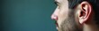 © miss irine - Close-up of man ear anatomy. Macro shot of human ear, earlobe, tragus. Right ear, profile view on background with copy space. Male portrait, beard, hair. Hearing aid demo, ear care, otolaryngology,