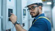 © Noppakun - A technician in a hard hat and glasses operates equipment in an industrial setting, showcasing expertise and safety in electrical work.