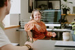 © AnnaStills - Wide shot of female programmer with down syndrome sitting on chair and looking at her male coworker