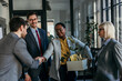 © La Famiglia - A group of coworkers is saying goodbye to an old colleague who is leaving the office. Concept of loosing job