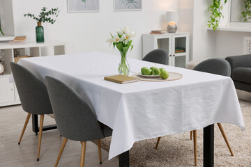 Poster - table with white tablecloth, apples, flowers in vase and chairs in stylish room. interior design