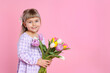 © New Africa - Smiling little girl with bouquet of tulips on pink background. Space for text