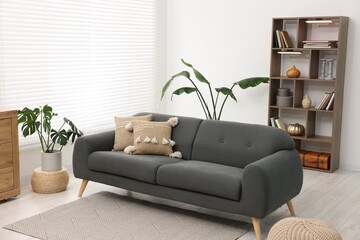 Poster - stylish living room with comfortable sofa and wooden shelving unit. interior design