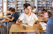 © JackF - Boy gives the read books to the librarian in the school library