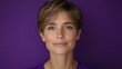 © JO BLA CO - A woman with short hair and a subtle smile is centered against a vivid purple background. Her expression conveys calmness and confidence, creating a serene atmosphere