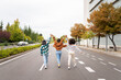 © Santi Nuñez/Stocksy - Three young women walking down a city street holding hands