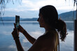 © Luis Herrera/Stocksy - woman taking a photo at a lake