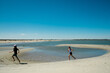 © Maria Manco/Stocksy - Kids run through tidal pool on beach