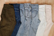 © Julia Isaeva/Stocksy - A row of folded trousers and jeans in various shades