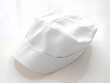 © Nichapa888 - A professional shot of a white nurse hat on a soft white surface, illuminated by diffused light