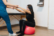 © Daniel Zapata/Stocksy - Unrecognizable chiropractor performing stretches with her patient.