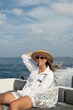 © Alina Hvostikova/Stocksy - Woman enjoying a boat ride on a sunny day near the coast