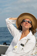 © Alina Hvostikova/Stocksy - Woman enjoying a sunny boat ride on a calm ocean