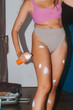 © Alina Hvostikova/Stocksy - Woman standing applying cream