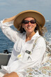 © Alina Hvostikova/Stocksy - Smiling woman enjoys a boat ride on a sunny day at sea