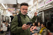 © Hernandez & Sorokina/Stocksy - Man using phone in metro