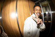 © Jimena Roquero/Stocksy - Portrait in elevator of young man smiling at camera. Fisheye