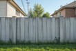 © Kitta Studio - Wooden fence with grass and homes in the background on a sunny day