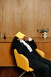 © Sergey Narevskih/Stocksy - Woman in suit covering face with notebook, burnout