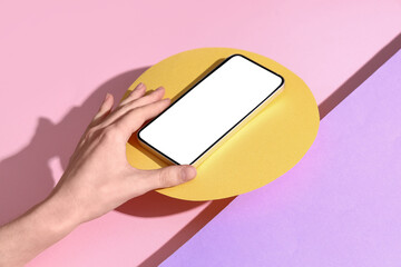 Wall Mural - female hand with mobile phone on color background
