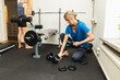 © Diego Martin/Stocksy - Woman Preparing Dumbbells for Exercise in Home Gym