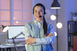 © Pixel-Shot - Young woman with headset at office in evening