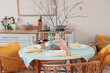 © Pixel-Shot - Beautiful Easter table setting with rabbits and tree branches in kitchen