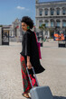 © tessy morelli/Stocksy - Fashionable tourist walking in Lisbon Cais do Sodre