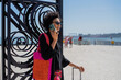 © tessy morelli/Stocksy - Lisbon Cais do Sodre traveler with suitcase on phone call portrait