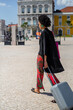 © tessy morelli/Stocksy - Following a woman wlaking with suitcase