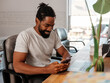 © B Krokodil/Stocksy - Smiling Man Checking Phone at a Desk with Laptop