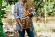 © Evgeniia Siiankovskaia/Stocksy - Senior man holding a bunch of garlic from his garden.