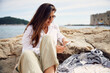 © Boris Jovanovic/Stocksy - Stylish woman relaxes on the rocky beach