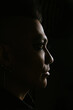 © VICTOR TORRES/Stocksy - Dramatic male profile with mohawk in dark shadowy lighting